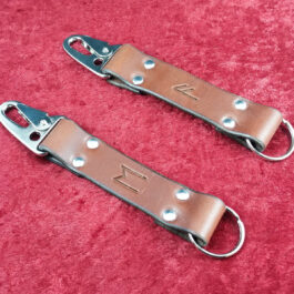 A pair of Handmade Leather Keychains on a red carpet.