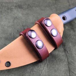 a Scout Style Benchmade Bushcrafter Kydex Sheath with two leather straps on it.