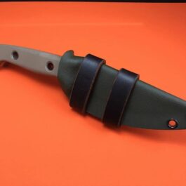 a Scout Style Benchmade Bushcrafter Kydex Sheath with a leather handle on an orange surface.