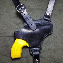 A Handmade Leather Shoulder Holster with a yellow plastic gun.