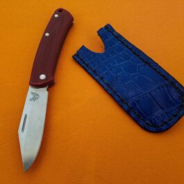 A Leather Pocket Slip for the Benchmade Proper is laying next to a blue case.