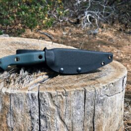 a Benchmade Bushcrafter Kydex Sheath sitting on top of a tree stump.