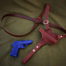 a red Handmade Leather Shoulder Holster and a blue plastic gun.