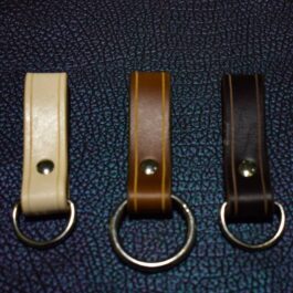 A couple of Leather Dangler Loops sitting on top of a blue surface.