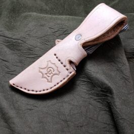 a Leather Sheath For The Benchmade Hidden Canyon Hunter on a green cloth.