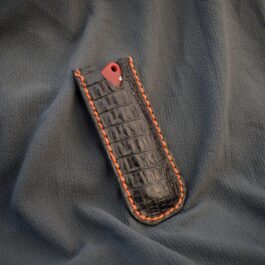 a Leather Pocket Slip for the Benchmade Proper with an orange stitch on it.