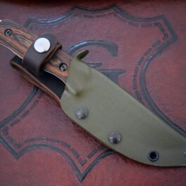 a knife with a leather sheath on top of it.