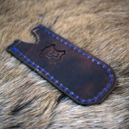 A Leather Pocket Slip for the Benchmade Proper sitting on top of a furry surface.
