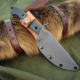 A Benchmade Bushcrafter Kydex Sheath is laying on a green cloth.