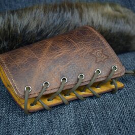 An Upgraded Handmade Leather Buttstock Cover with a fur tail on top of it.
