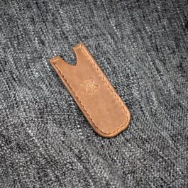 A Handmade Leather Pocket Slip laying on a piece of fabric.