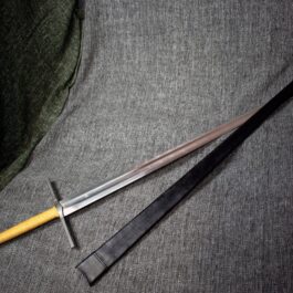 a pair of swords laying on top of a gray cloth.