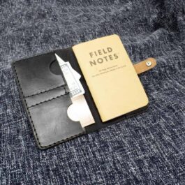 a Field Notes Wallet with a pair of scissors sticking out of it.