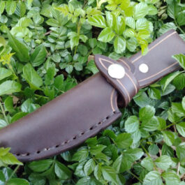 A handmade leather sheath for the Lionsteel M4 with a hole in the middle of it.