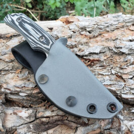 A Benchmade Hidden Canyon Hunter knife resting in a Vertical Kydex Sheath on a piece of wood.