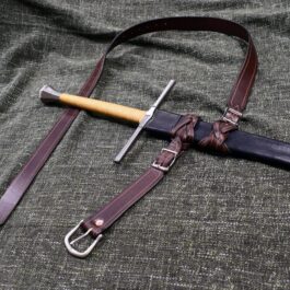An Integrated Swordbelt Style 4 and its sheath laying on a cloth.