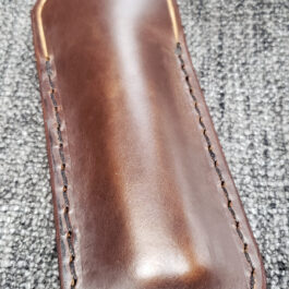 A Leather Balisong Slip sitting on top of a gray cloth.