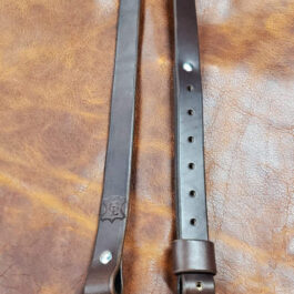 A dark brown Simple Rifle Sling laid on a brown leather cloth - Grommet's Leathercraft - renaissance clothing - renaissance art clothing - renaissance era clothing - leathercraft supplies - leathercraft accessories - leathercraft store near me - quality leather craft