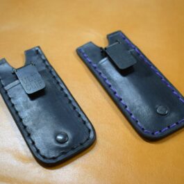 Two Leather Pocket Slips for the Benchmade Tengu w' Pocket Clip sitting on top of a table.