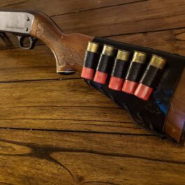 A Handmade Leather Buttstock Cover on a wooden table.