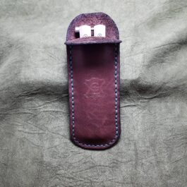 A purple Leather Balisong Slip with two dice holders in it.