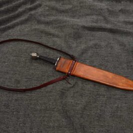 a Custom Wood Core Scabbard laying on top of a gray cloth.