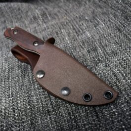a knife with a leather sheath on a gray cloth.