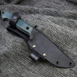 a Benchmade Bushcrafter Kydex Sheath laying on top of a gray cloth.