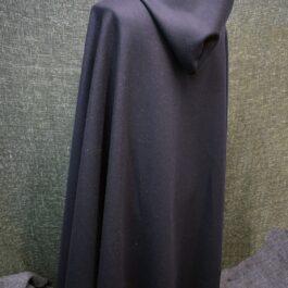 A Wool Hooded Cloak sitting on top of a couch.