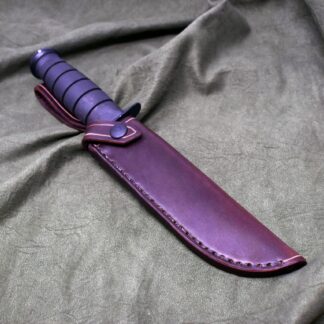 a Handmade Leather Sheath for the Full Size Ka-Bar laying on top of a gray cloth.