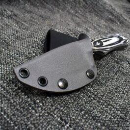 A Vertical Kydex Sheath for Benchmade Hidden Canyon Hunter is laying on a piece of fabric.