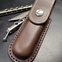 A molded leather belt pouch with a Benchmade Balisong and a pair of scissors.