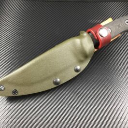 The TOPS HOG 4.5 Kydex Sheath with a red handle sitting on top of a table.