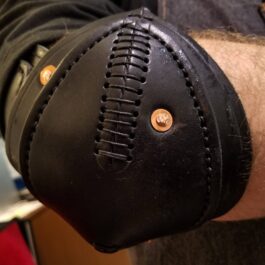 a close up of a person wearing a leather wristband.