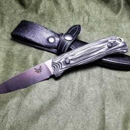 a knife that is laying on a cloth.