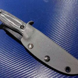 The Kydex Sheath for the Benchmade Saddle Mountain Hunter is laying on a blue surface.