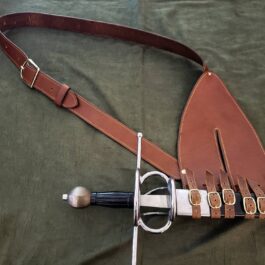 A Renaissance Baldric and a leather case laying on a bed.