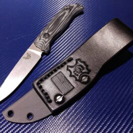 a Benchmade Saddle Mountain Hunter knife and a Kydex sheath on a blue surface.