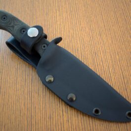 a TOPS HOG 4.5 Kydex Sheath with a black handle on a wooden table.