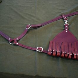 a purple bridle with a comb of hair attached to it.