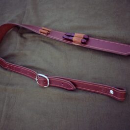 A burgundy Handmade Leather Rifle Sling with ammunition laid on a cloth - Grommet's Leathercraft - renaissance clothing - renaissance art clothing - renaissance era clothing - leathercraft supplies - leathercraft accessories - leathercraft store near me - quality leather craft