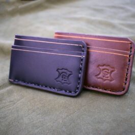 a couple of wallets sitting on top of a bed.