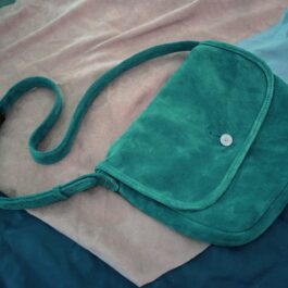 green Frontier Suede Saddlebag laid on a cloth - renaissance clothing - renaissance clothing men - renaissance clothing women - renaissance clothing near me - renaissance art clothing - renaissance era clothing - renaissance costume ideas