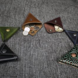 A group of Handmade Leather Coin Pouches sitting on top of a couch.