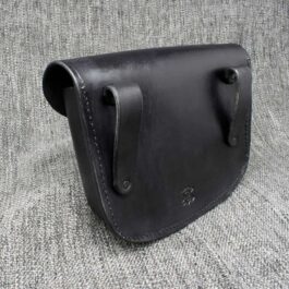 A molded leather belt pouch sitting on top of a couch.
