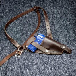 a brown leather holster with a blue tag on it.