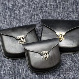 three black Molded Leather Belt Pouch laid on a cloth- renaissance clothing - renaissance clothing men - renaissance clothing women - renaissance clothing near me - renaissance art clothing - renaissance era clothing - renaissance costume ideas