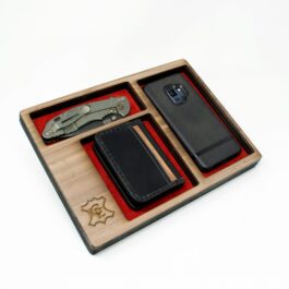 A Wooden Valet Tray containing a cell phone, wallet, and knife.