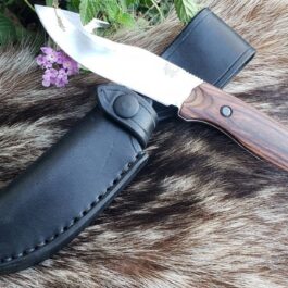 A Vertical Leather Sheath For The Benchmade Saddle Mountain Skinner is laying on top of a fur.