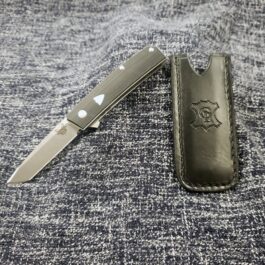 A Leather Pocket Slip for the Benchmade Tengu laying on top of a piece of cloth.